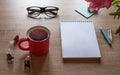 Still life on a table made of light wood. A white Notepad, a Cup of tea,, flowers Royalty Free Stock Photo