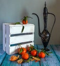 Still life with tangerines, a jug and a box. Ripe citrus fruits. Royalty Free Stock Photo