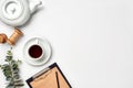 Still life with tea cup and the contents of a workspace composed. Different objects on white table. Flat lay