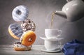 Still life with tea and falling down donuts Royalty Free Stock Photo
