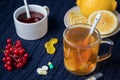Still life of tea with lemon, tablets and thermometer, jam and berries. The concept of treating colds Royalty Free Stock Photo