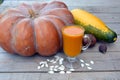 Still life with a textured pumpkin, vegetables and a glass of diet pumpkin juice