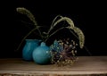 Still life with three blue vases, ears of corn and a flower of an onion bulb