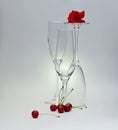 Still life of three glasses with a rose and cherries Royalty Free Stock Photo