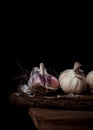 Still life of three heads of garlic on a wood