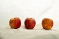 Still life of three red yellow apple fruit for food on white beige fabric background in classic style Royalty Free Stock Photo