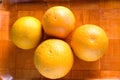 Still life with three ripe tasty oranges on brown tray