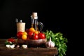 Still life of tomatoes, garlic and olive oil on wooden boards. On a black background. Royalty Free Stock Photo