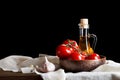 Still life of tomatoes, garlic and olive oil on wooden boards. On a black background. Royalty Free Stock Photo