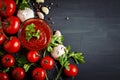 Still life with tomatoes, garlic, parsley, tomato sauce and pepper on black wooden boards. Royalty Free Stock Photo