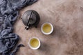 Still life with traditional Asian herbal tea, cooked in an old cast-iron kettle on a textured background with a bowl Royalty Free Stock Photo