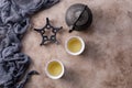 Still life with traditional Asian herbal tea, cooked in an old cast-iron kettle on a textured background Royalty Free Stock Photo