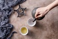 Still life with a traditional Asian herbal tea, which is poured from an old cast-iron kettle on a textured background with pialami Royalty Free Stock Photo