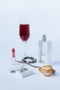 A still life with a transparent perfume bottle, a faded rose, a bracelet, a lipstick, a box with the silver earrings Royalty Free Stock Photo