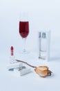 A still life with a transparent perfume bottle, a faded rose, a lipstick, a box with the silver earrings, and the glass Royalty Free Stock Photo