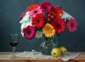Still life with Transvaal daisies, apples and red wine. Royalty Free Stock Photo