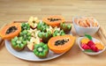 Still life. A tray with papaya, kiwi, apples. Pieces of tangerines and watermelon in plates. Royalty Free Stock Photo