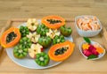 Still life. A tray with papaya, kiwi, apples. Pieces of tangerines and watermelon in plates. Royalty Free Stock Photo