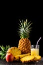 Still life with tropical fruits and glass of juice on a black r Royalty Free Stock Photo