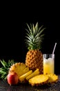 Still life with tropical fruits and glass of juice on a black r Royalty Free Stock Photo