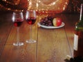 Still life with two glasses of red wine in focus, Bottle and cork in foreground out of focus, Plate with grapes and apple out of Royalty Free Stock Photo