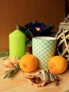 Still life - two lemons, two sea shells, green decorative candle and a mug on a table