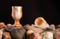 Still life with two onyx glasses on a pile of pebble and shells