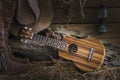 Still life with ukulele on cowboy hat and traditional leather bo Royalty Free Stock Photo