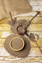 Still life with unloaded bulk dried lentils on a table and a copper june meter with a bamboo wooden bowl, wooden spoons and