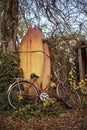 A still life of a vintage bicycle and paddle boards during an autumn month