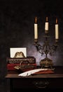 Still life with vintage books, bronze candlestick, Feather pen, envelopes and press papier. Royalty Free Stock Photo