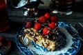 Still life in royal style. Close up piece of chocolate cake with raspberries on old blue plate, beside glass fruit drink on silver