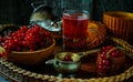 Still life in vintage style. Close up glass with red current tea or fruit-drink and wooden bowl Royalty Free Stock Photo