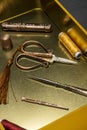 A still life with vintage style sewing utensils with scissors, thimble and spools of thread in a gold metal box Royalty Free Stock Photo