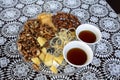 Still life of walnuts almonds honey in two cups table on a white tablecloth