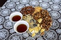 Still life of walnuts almonds honey in two cups table on a white tablecloth