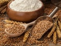 Still life with wheat, flour and spikelets in a spoon and bowl on an old table Royalty Free Stock Photo