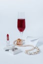 A still life with a white envelop, a faded rose bud, a coral necklace, a lipstick, a box with the silver earrings, and Royalty Free Stock Photo