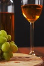 Still life with white juicy grapes, bottle of white wine without any label, and one wine glass. Royalty Free Stock Photo