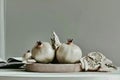 Still life with white pomegranates and open book on simple white table Royalty Free Stock Photo