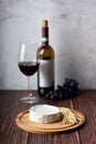 Still life of wine, cheese and grapes on wooden table Royalty Free Stock Photo