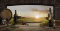 Still life with wine glasses, bottles, grapes on wooden table in wine cellar. Panoramic window view of lush vineyards at Royalty Free Stock Photo