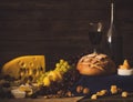 Still life with wine, grapes, bread and various sorts of cheese. Royalty Free Stock Photo