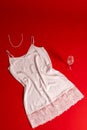 Still life: women`s white openwork shirt on a red background