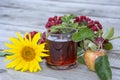 Still life on a wooden background. Black tea in a glass cup, sunflower flower, apples and rowan branch, top view Royalty Free Stock Photo