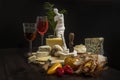 Still life with a wooden board full of delicious cheeses, tomatoes, strong garlic,