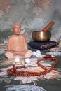 Wooden buddha, sound bowl and wooden praying pearls