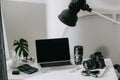 Still life working from home desk with professional photographic equipment, camera, lens, computer monitor, electronics indoors Royalty Free Stock Photo