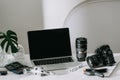 Still life working from home desk with professional photographic equipment, camera, lens, computer monitor, electronics indoors Royalty Free Stock Photo