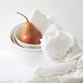 Still life with yellow-red pear Duchess in a pile of bowls and a white embroidered napkin on the white wall Royalty Free Stock Photo